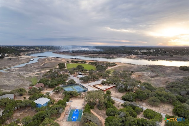 aerial view at dusk featuring a water view