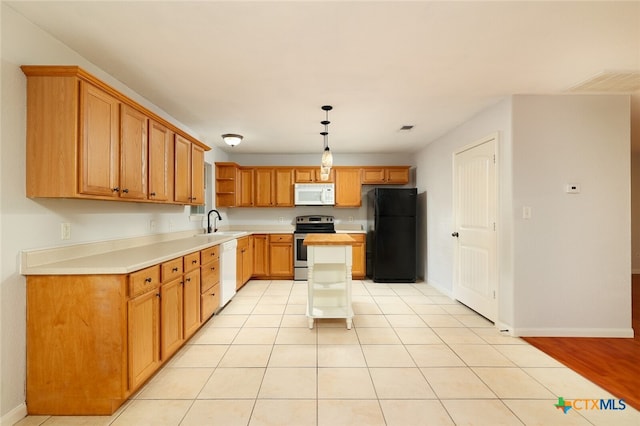 kitchen featuring pendant lighting, sink, light hardwood / wood-style floors, white appliances, and a center island