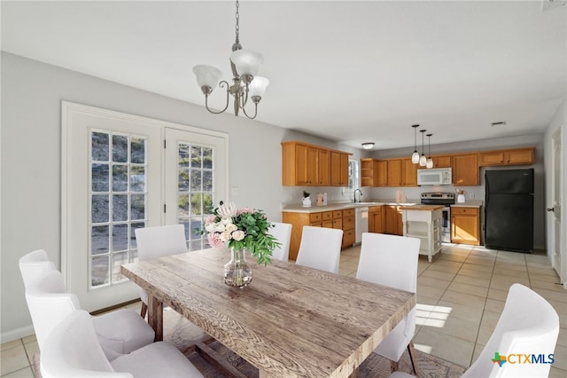 tiled dining room with sink and an inviting chandelier