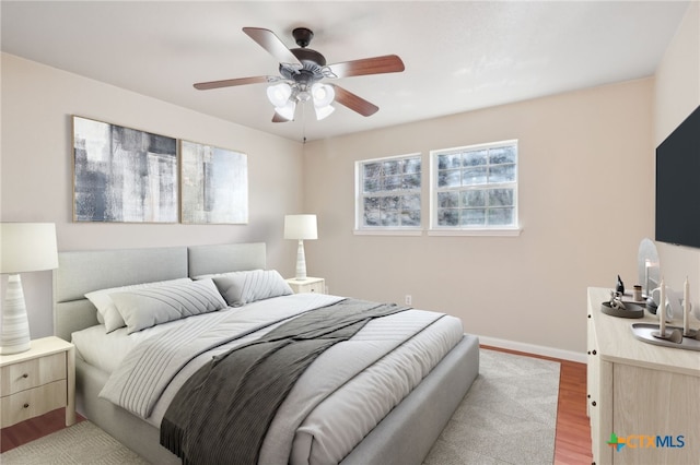 bedroom with light wood-type flooring, multiple windows, and ceiling fan