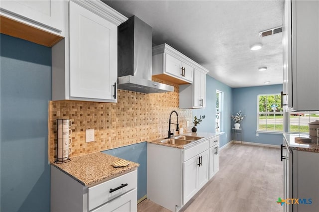 2603 Lone Tree Rd, Victoria, TX 77901 - kitchen with a sink, wall chimney exhaust hood, light wood-type flooring, and light stone counters
