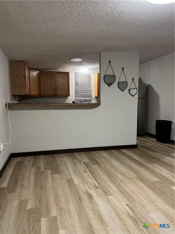 interior space featuring light hardwood / wood-style floors and a textured ceiling