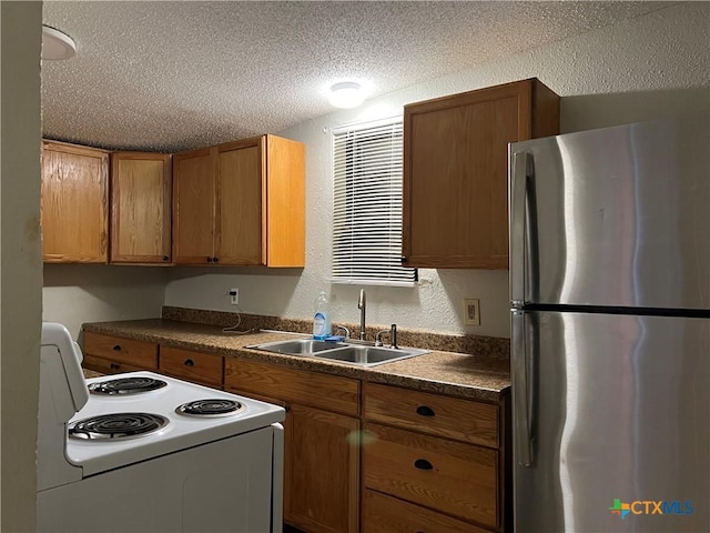 kitchen with stainless steel fridge, sink, white electric range oven, and a textured ceiling