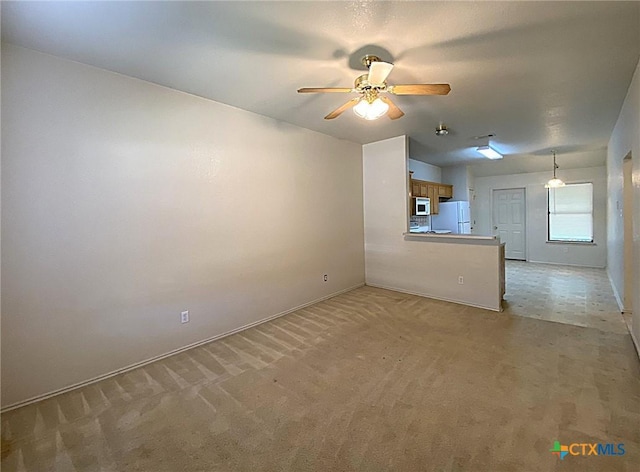 unfurnished living room with light carpet and ceiling fan