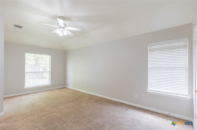 spare room with baseboards, visible vents, ceiling fan, and light colored carpet