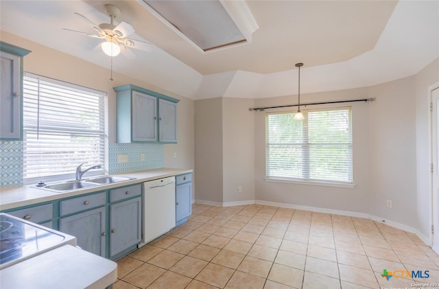 kitchen featuring white dishwasher, decorative backsplash, light countertops, and a sink