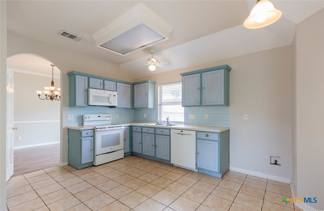 kitchen featuring arched walkways, white appliances, visible vents, light countertops, and backsplash