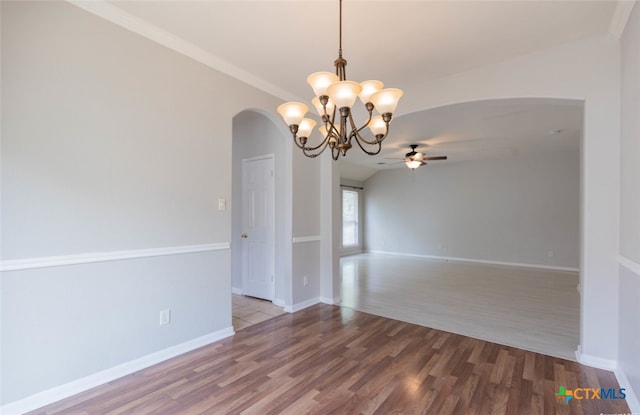 unfurnished room with baseboards, arched walkways, wood finished floors, and ceiling fan with notable chandelier