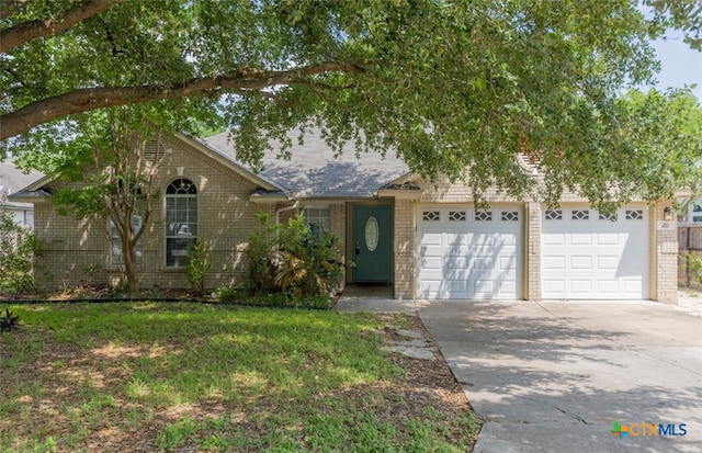 view of front of house with a garage, brick siding, and driveway