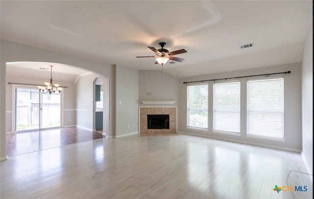 unfurnished living room with baseboards, visible vents, wood finished floors, and a tile fireplace