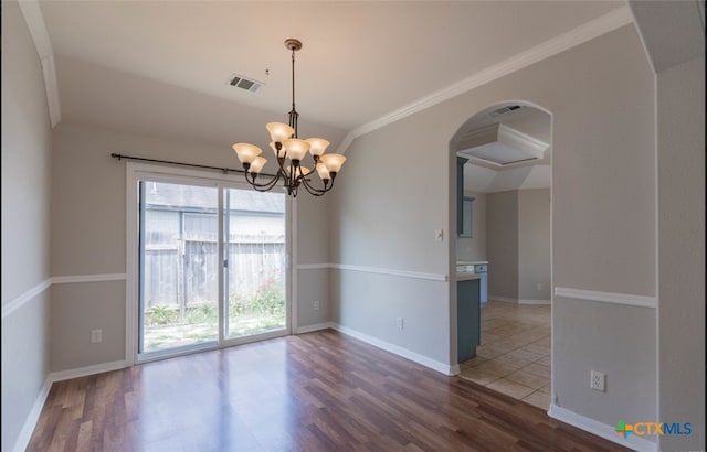 unfurnished room featuring an inviting chandelier, visible vents, baseboards, and wood finished floors