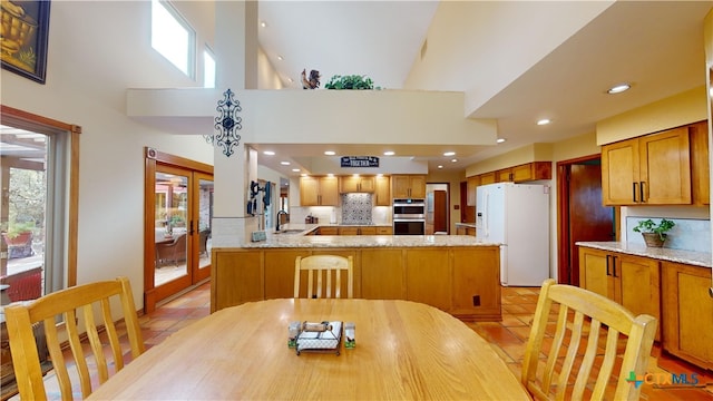 dining room featuring plenty of natural light, light tile patterned floors, and a high ceiling