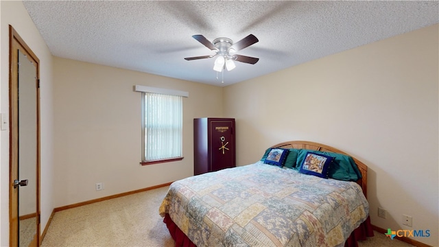 carpeted bedroom featuring ceiling fan and a textured ceiling