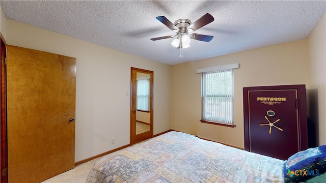 carpeted bedroom with ceiling fan and a textured ceiling