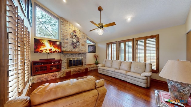 living room with a fireplace, a wealth of natural light, hardwood / wood-style floors, and high vaulted ceiling