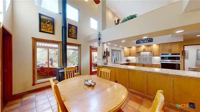 dining area with sink and high vaulted ceiling