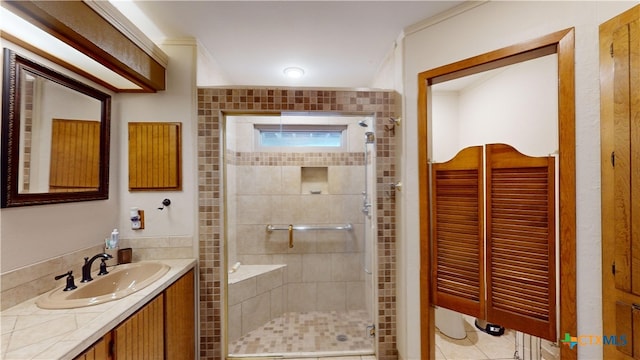 bathroom with tile patterned flooring, vanity, a shower with door, and ornamental molding