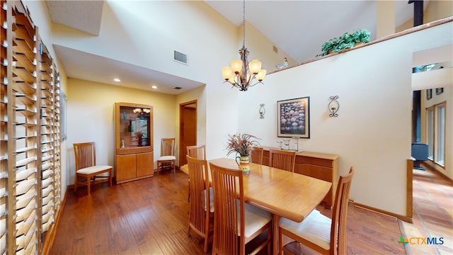 dining space featuring dark hardwood / wood-style floors, high vaulted ceiling, and an inviting chandelier