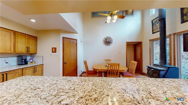 kitchen with ceiling fan and light stone counters