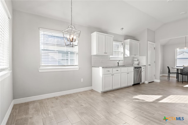 kitchen featuring stainless steel dishwasher, lofted ceiling, light hardwood / wood-style floors, and white cabinets