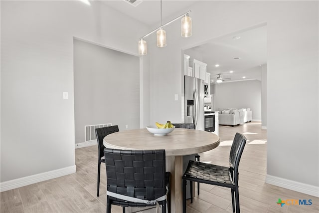 dining space with ceiling fan and light hardwood / wood-style flooring