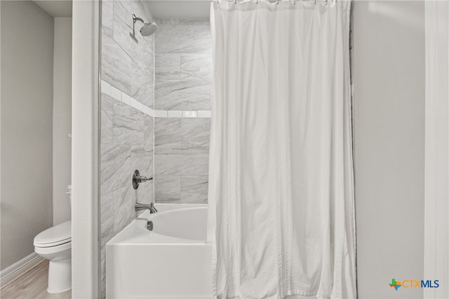 bathroom featuring shower / bath combo, hardwood / wood-style flooring, and toilet