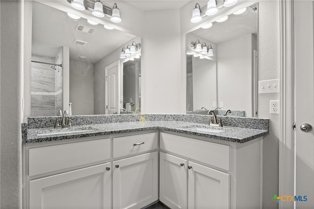 bathroom with vanity and a tile shower