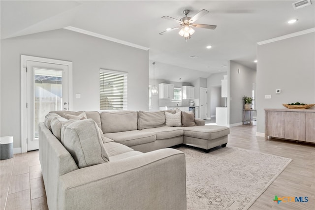 living room with ornamental molding, light hardwood / wood-style floors, lofted ceiling, and ceiling fan