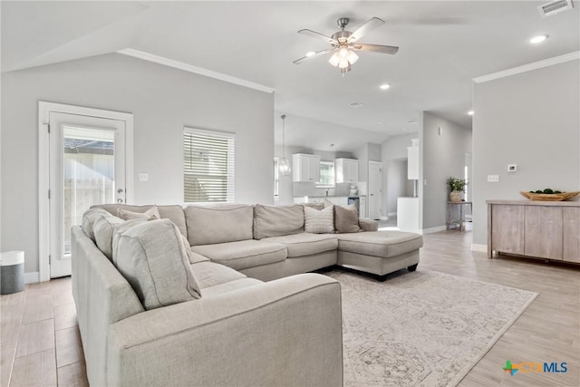 1519 Curlew Ln, Temple, TX 76502 - living room featuring a ceiling fan, light wood-style floors, vaulted ceiling, baseboards, and ornamental molding