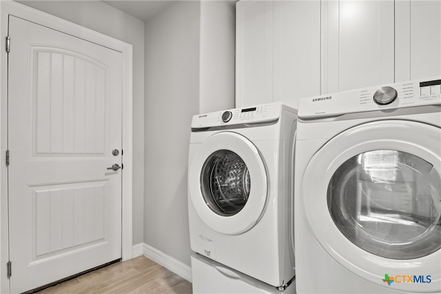 laundry room featuring washing machine and clothes dryer and light hardwood / wood-style floors