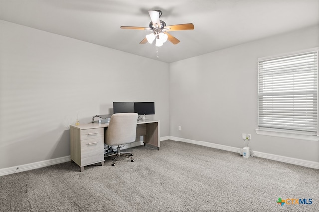 carpeted home office featuring ceiling fan