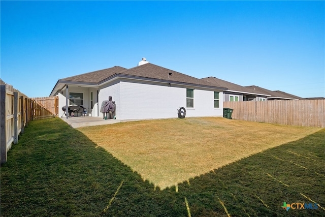 rear view of property with a lawn and a patio area