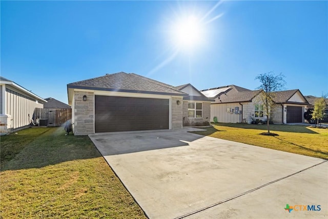 1519 Curlew Ln, Temple, TX 76502 - ranch-style home featuring driveway, stone siding, a front yard, and an attached garage
