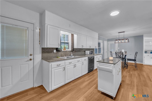 kitchen with a kitchen island, beverage cooler, white cabinetry, and a sink