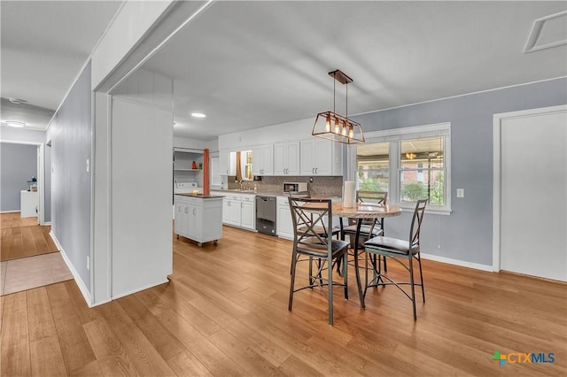 dining area with visible vents, light wood-style flooring, and baseboards