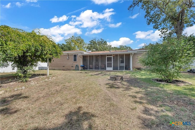 back of house featuring crawl space, a sunroom, and a lawn