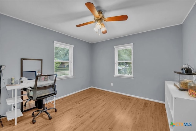 office space with ornamental molding, wood finished floors, a ceiling fan, and baseboards