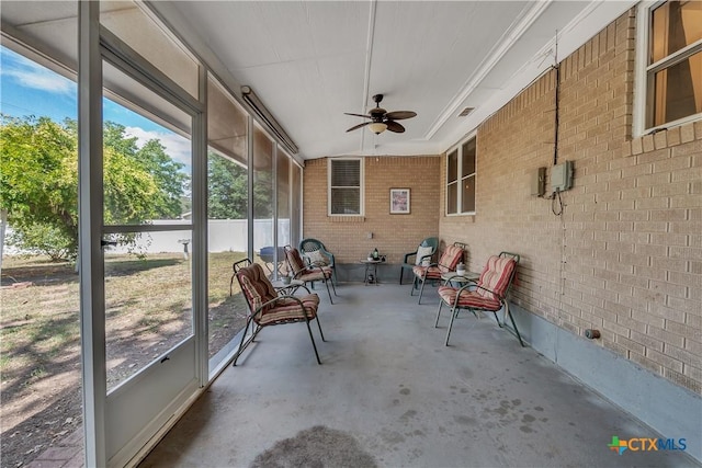 unfurnished sunroom with ceiling fan