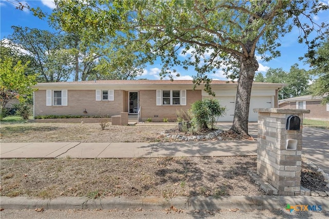 single story home featuring an attached garage, crawl space, and brick siding