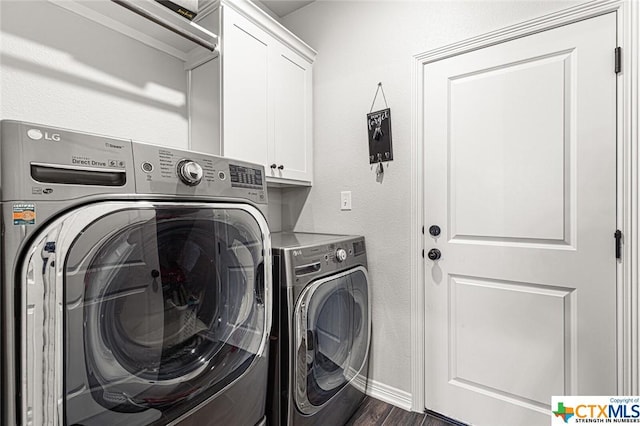 clothes washing area with separate washer and dryer, cabinet space, dark wood-style flooring, baseboards, and a textured wall