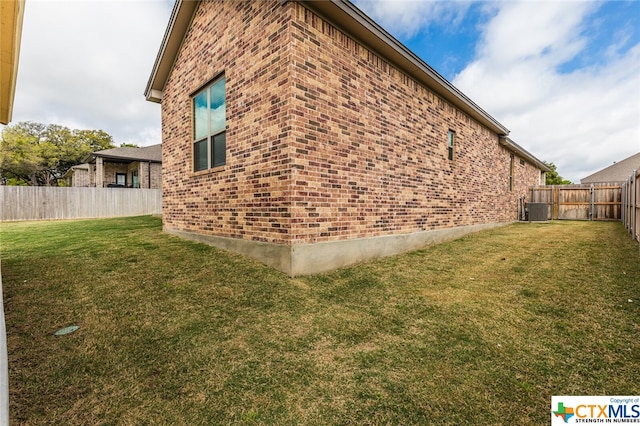 view of property exterior with central AC unit and a lawn