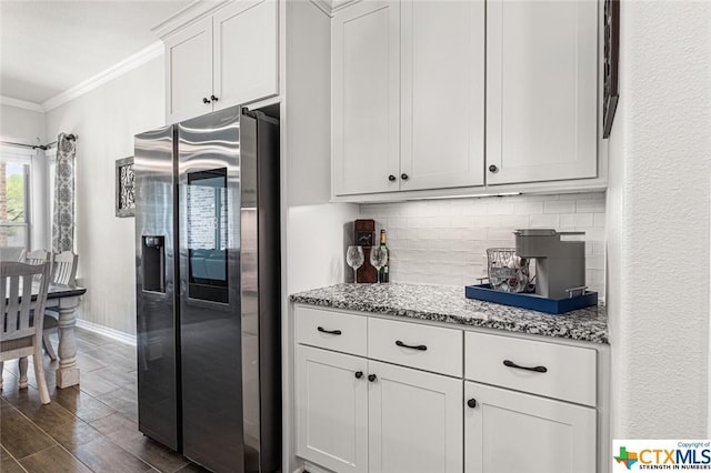 kitchen with stainless steel fridge, dark wood-type flooring, ornamental molding, backsplash, and baseboards
