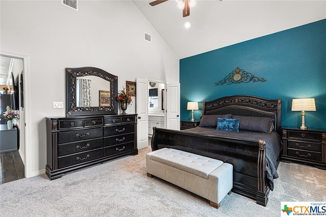 bedroom featuring ceiling fan, ensuite bath, high vaulted ceiling, and carpet