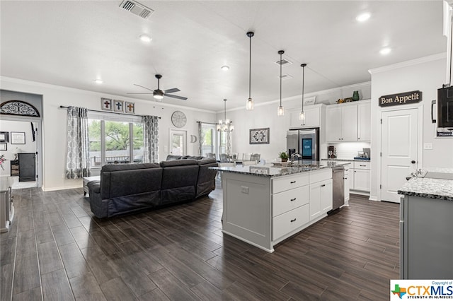 kitchen with white cabinets, light stone countertops, a kitchen island with sink, and appliances with stainless steel finishes