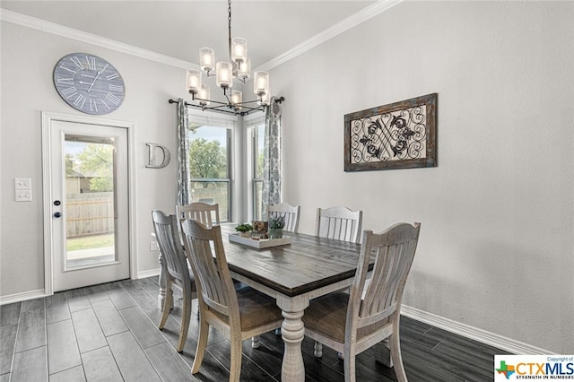 dining area featuring a chandelier, ornamental molding, baseboards, and wood tiled floors