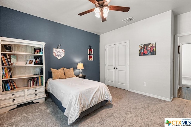 carpeted bedroom with a closet, ceiling fan, and baseboards