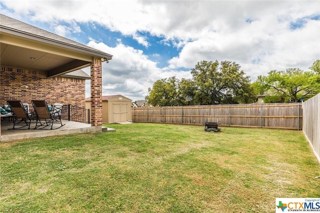 view of yard with a patio, a shed, and an outbuilding