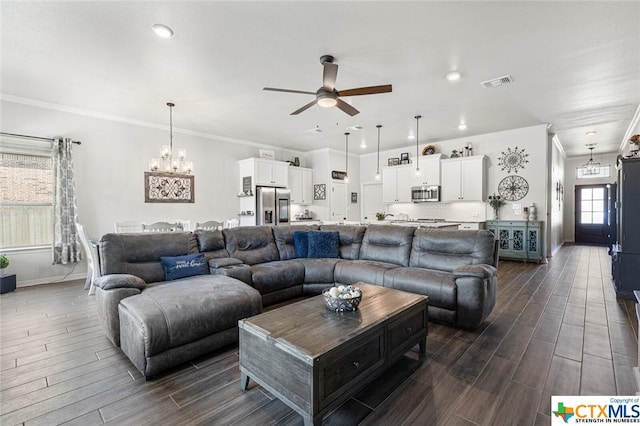 living room with a ceiling fan, wood tiled floors, crown molding, baseboards, and a chandelier
