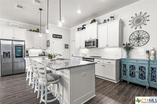 kitchen featuring white cabinets, an island with sink, and appliances with stainless steel finishes