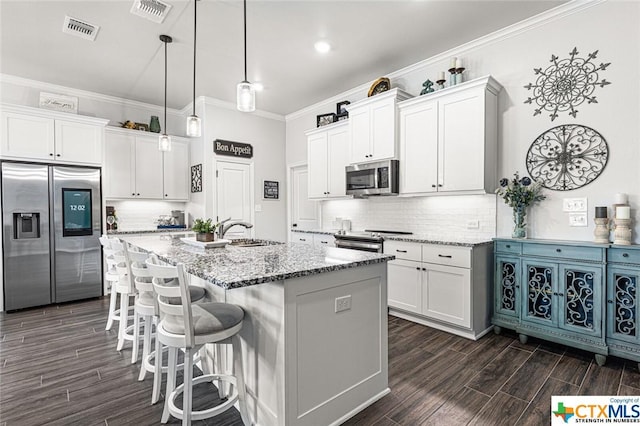 kitchen with appliances with stainless steel finishes, a sink, light stone countertops, dark wood-style flooring, and crown molding